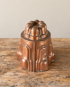 Side view of a French late nineteenth-century copper jelly mould has a finely articulated oval form. Stepped Gothic arches encircle the body beneath a crown of eight rounded lobes.