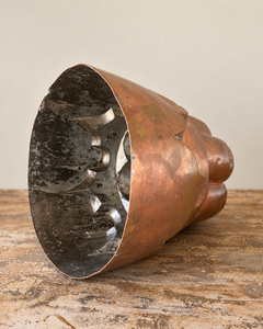 A striking nineteenth-century French copper jelly mould with a tall, tiered silhouette, rounded upper lobes and an architectural scalloped base.