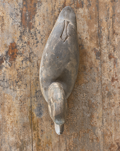 An arial view of a beautifully sculptural vintage wooden duck, with a gently curved neck, rounded breast and long, tapering tail. Its simple carved features give it an endearing expression, while the low, elegant silhouette is particularly lovely in profile.